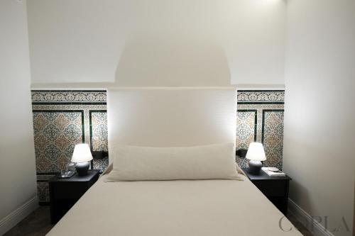 a bed with two night stands and two lamps at Cool&Modern Apt para 4pax en el centro de Sevilla in Seville