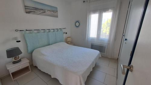 Habitación blanca con cama y ventana en Lisboa 4 - Piso con piscina comunitaria, en Roses