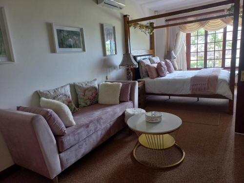 a living room with a couch and a bed at Forest Dream House in Kloof