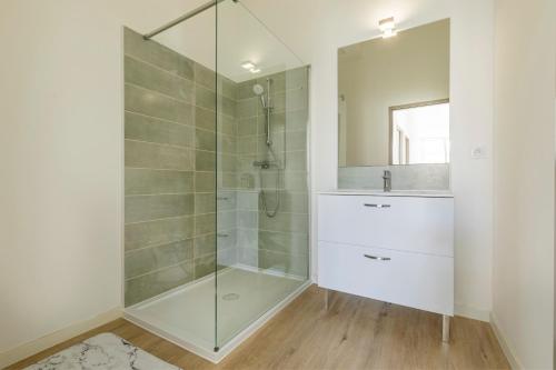La salle de bains est pourvue d'une douche en verre et d'un lavabo. dans l'établissement LE SICRE - T3 confort, centre Castelsarrasin, parking, à Castelsarrasin