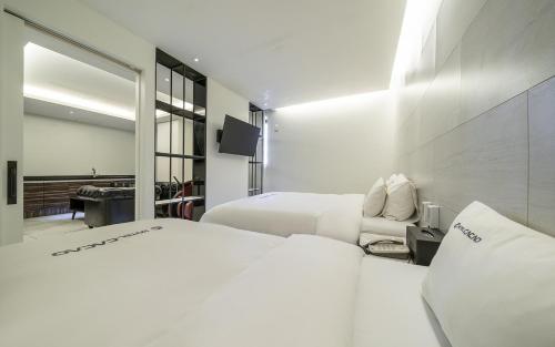 a hotel room with two beds and a mirror at Cacao Hotel in Incheon