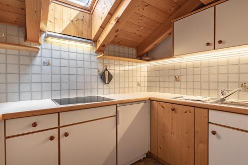 uma cozinha com armários brancos e um lavatório em Apartment Ruiel em Santa Cristina in Val Gardena