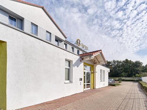 a white building with a sign on top of it at B&B Hotel Köln-Airport in Cologne