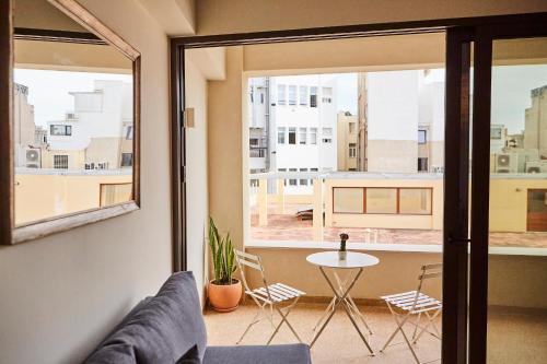 a living room with a table and chairs and a window at Mosaics Athens Boutique Apartments in Athens
