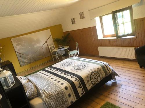 Un dormitorio con una cama con una manta. en La chambre Cour'toise, en Stoumont