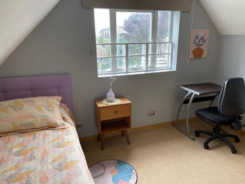 1 dormitorio con cama, escritorio y silla en Casa del Arce, en Puerto Varas