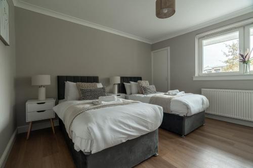 a bedroom with two beds and a window at Shaw Apartment in Glasgow