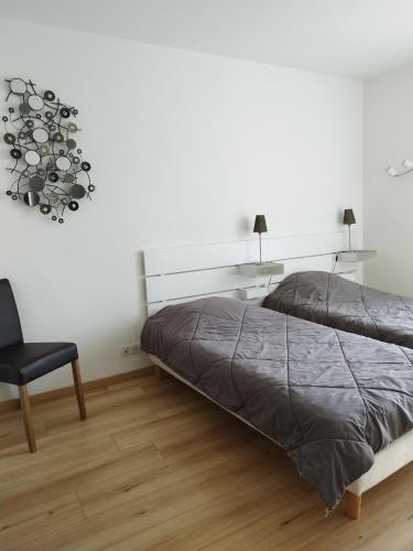 - une chambre avec un lit et une chaise noire dans l'établissement Mon petit Paradis, Cassis centre Apt 90 m2, 200 m Mer, terr plein sud, clim park privé, à Cassis