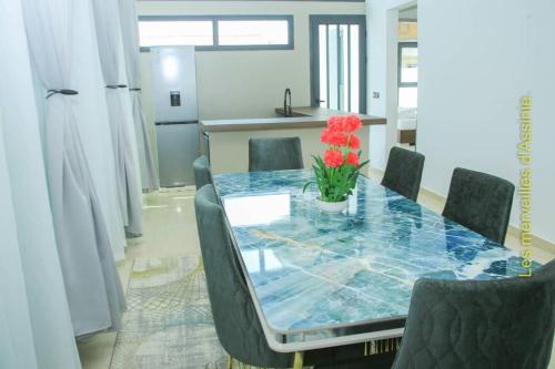 a dining room table with a vase of flowers on it at Les merveilles d’assinie in Assinie