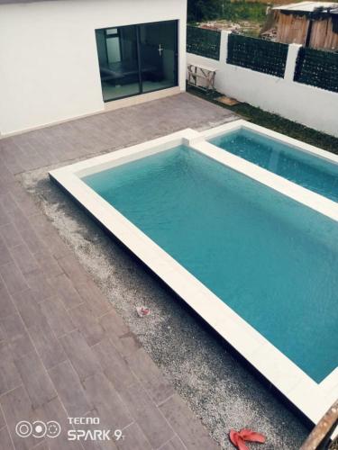 a swimming pool in front of a house at Les merveilles d’assinie in Assinie