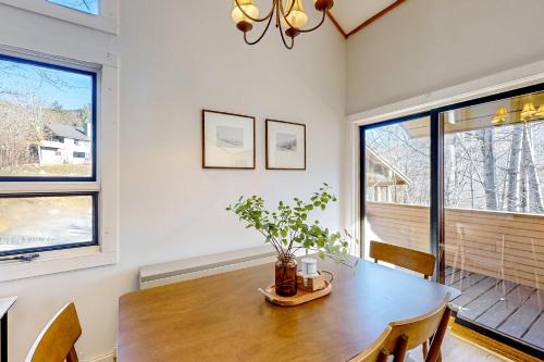 a dining room with a wooden table and two windows at Moon River Lodge in Lincoln