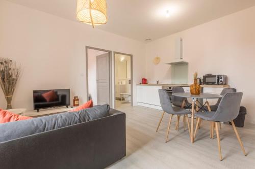 a living room with a couch and a table at LE CORAIL - 1 chambre, idéal couple, parking, 10min Canal du Midi in Castelsarrasin