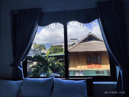 a large window with a view of a building at Tua's Homestay in Mai Châu