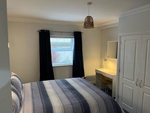 a bedroom with a bed and a desk and a window at Rockmount Court in Bournemouth