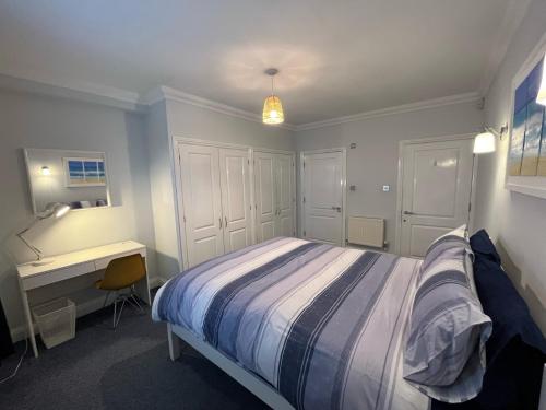 a bedroom with a bed and a desk in it at Rockmount Court in Bournemouth