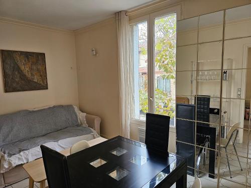 un salon avec un lit et une table en verre dans l'établissement Appartement pour 1à 4 personnes sans cuisine, à Alfortville