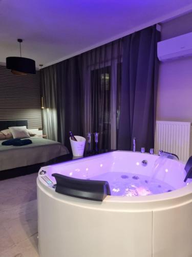a bath tub in a room with a bedroom at Apartament Jacuzzi in Kraków