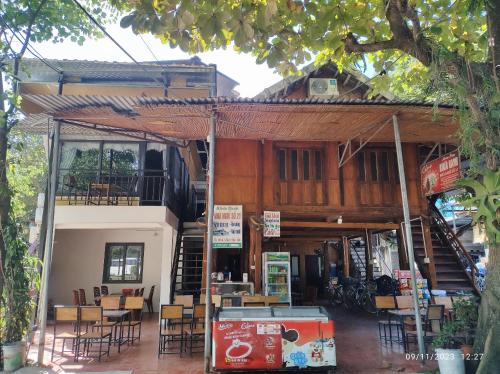 um restaurante com mesas e cadeiras em frente a um edifício em Tua's Homestay em Mai Châu