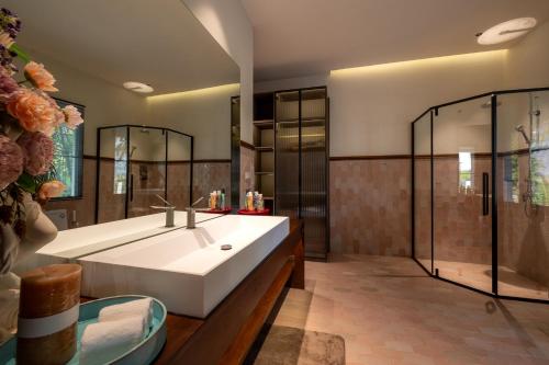 ein Badezimmer mit einer großen weißen Badewanne und einer Dusche in der Unterkunft Entire Luxury Private Pool Villa No.8 Chiang Mai in Chiang Mai