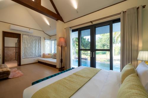 ein Schlafzimmer mit einem großen Bett und großen Fenstern in der Unterkunft Entire Luxury Private Pool Villa No.8 Chiang Mai in Chiang Mai