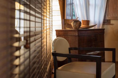 a chair sitting next to a window in a room at Boutique Hotel Poggio ai Santi - Adults Only in San Vincenzo