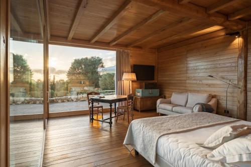 a bedroom with a bed and a large window at Boutique Hotel Poggio ai Santi - Adults Only in San Vincenzo