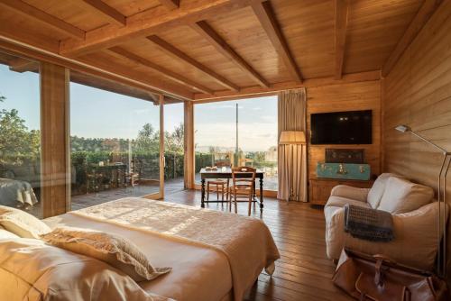 a bedroom with two beds and a large window at Boutique Hotel Poggio ai Santi - Adults Only in San Vincenzo