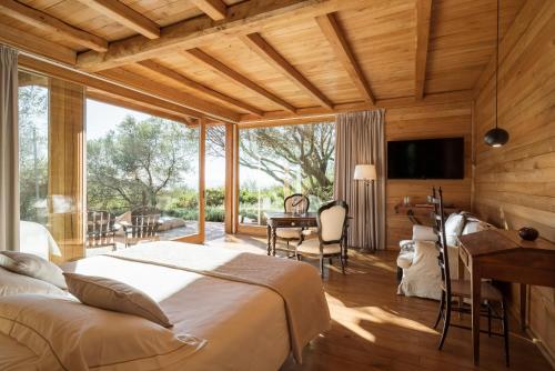 a bedroom with a bed and a desk and a television at Boutique Hotel - Poggio ai Santi in San Vincenzo