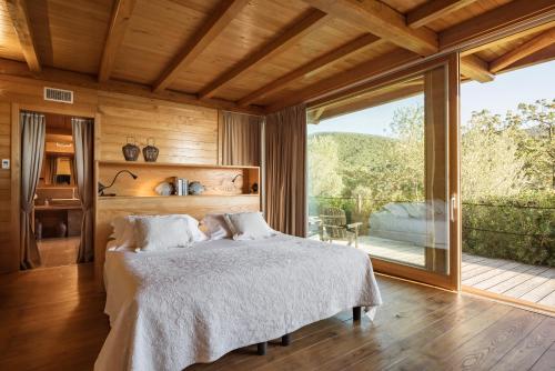a bedroom with a bed and a large window at Boutique Hotel Poggio ai Santi - Adults Only in San Vincenzo