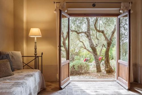 a bedroom with a door open to a tree at Boutique Hotel Poggio ai Santi - Adults Only in San Vincenzo