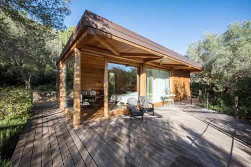 a log cabin with a deck with two chairs at Boutique Hotel Poggio ai Santi - Adults Only in San Vincenzo