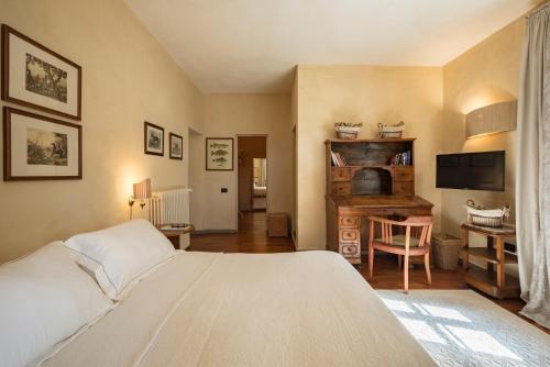 a bedroom with a bed and a desk with a television at Boutique Hotel Poggio ai Santi - Adults Only in San Vincenzo