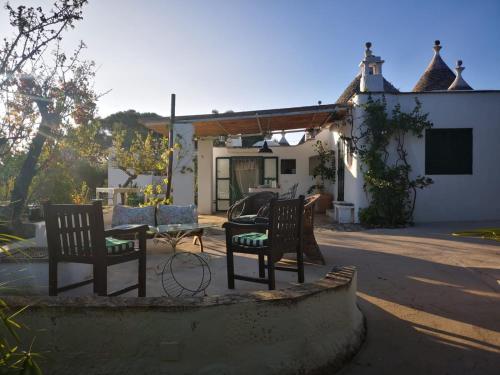 a patio with two chairs and a table in front of a house at Trulli di Ivana in Ostuni