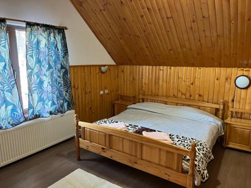 1 dormitorio con cama y techo de madera en Orehite Guest House, en Samokov