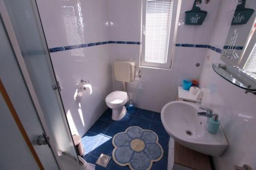 La petite salle de bains est pourvue de toilettes et d'un lavabo. dans l'établissement Apartments Luka, à Rogoznica