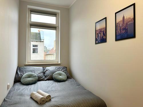 a bedroom with a bed with pillows and a window at MMRent New York Room in Gdańsk
