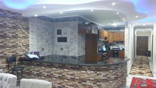 uma cozinha com um bar no meio de uma sala em Obour apartment, first district, Tabbah view em ‘Ezbet el-Insha