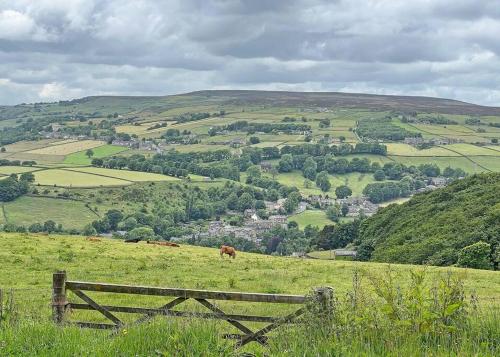 a view of a green field with a wooden fence at Apple Cottage: 19th Century Charm in Calder Valley in Luddenden Foot