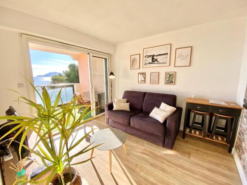 un salon avec un canapé et une grande fenêtre dans l'établissement Cannes Les Plages By SCLS Locations, à Cannes