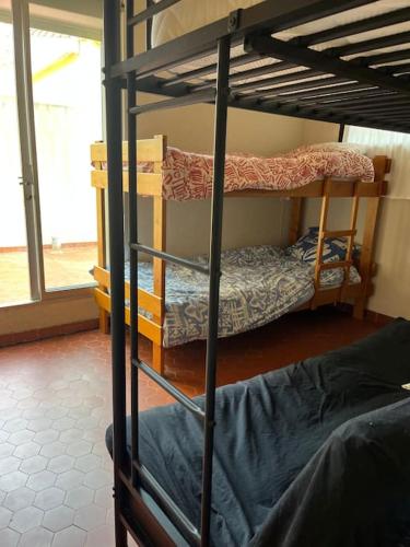 deux lits superposés dans une chambre avec fenêtre dans l'établissement Maison, au Barcarès