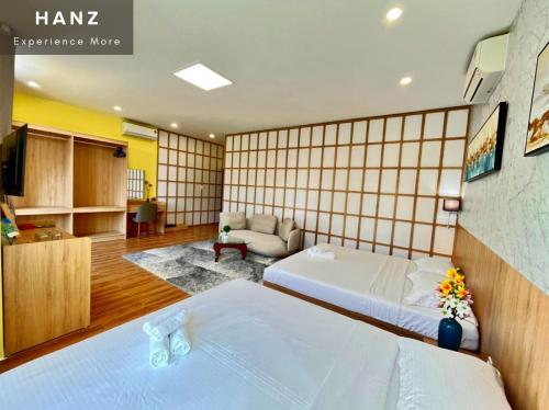 Habitación de hotel con 2 camas y sala de estar. en HANZ VeniceRiver Power MIA Grand World, en Phu Quoc