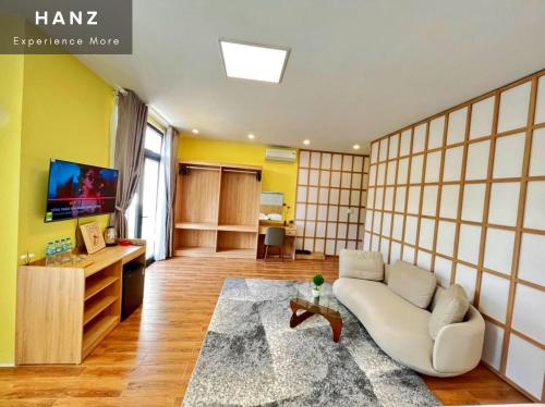 uma sala de estar com um sofá e uma televisão em HANZ VeniceRiver Power MIA Grand World em Phu Quoc