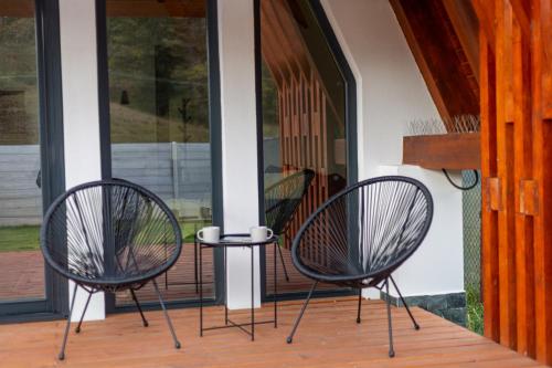 two black chairs sitting on a porch at Relax Cabins in Cristian