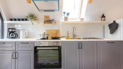 uma cozinha com armários brancos e um forno com placa de fogão em Relax Cabins em Cristian