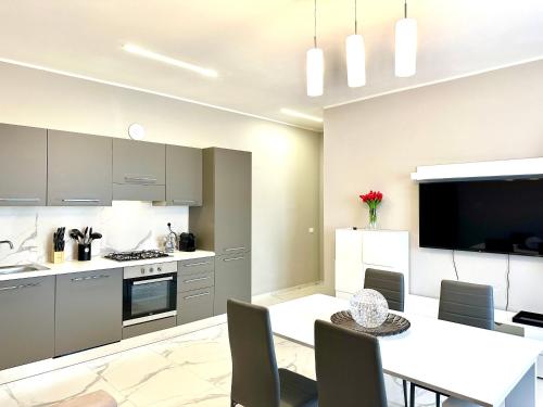 a kitchen and dining room with a table and a television at Donnino Apartments in Fidenza