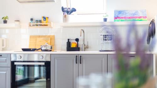 a kitchen with white cabinets and a sink at Relax Cabins in Cristian