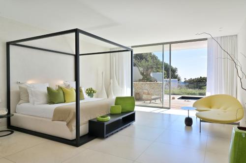 une chambre avec un lit à baldaquin et un salon dans l'établissement Hôtel Cala di Greco, à Bonifacio