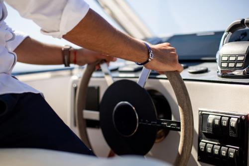 a person holding a steering wheel in a car at Hôtel Cala di Greco in Bonifacio