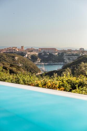 a view of a city and a body of water at Hôtel Cala di Greco in Bonifacio
