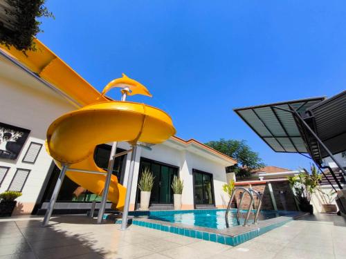 a slide in front of a house with a pool at Baan Big Family Pool Villa in Hua Hin